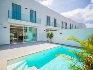 una casa con piscina delante en Alma Nomada Luxury Village, en Corralejo 48 fotos más