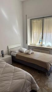 Dos camas en una habitación con ventana. en Ampio appartamento Albissola Marina, en Albissola Marina