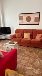 Una sala de estar con un sofá rojo y una mesa. en Ampio appartamento Albissola Marina, en Albissola Marina