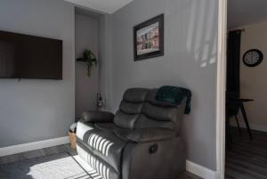 a living room with a couch and a flat screen tv at Caras Place , Falls Road in Belfast