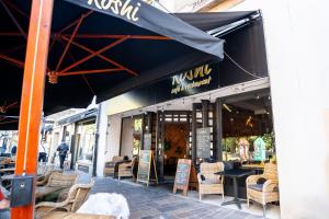 a restaurant with a blue awning and tables and chairs at Cozy Main Square Apartment II with Breakfast in Košice
