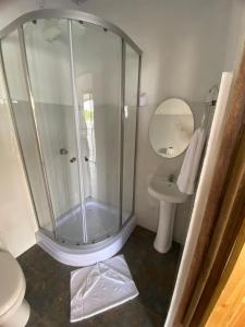 a bathroom with a shower and a toilet and a sink at Apartamento Lirios del Río in Tortuguero