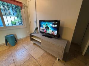 una TV a schermo piatto seduta su un tavolo in camera di Escapade entre Mer et Montagnes a Saint-Martin-du-Var