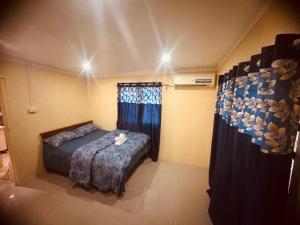 a small bedroom with a bed and a window at VULA Bnb in Suva