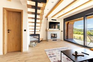 a living room with a staircase and a fireplace at Bjelašnica Lodges in Bjelašnica