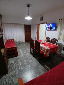a room with a table and chairs and a tv at Alquileres Irma in San Clemente del Tuyú