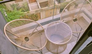 three rattan chairs sitting on top of a balcony at Pied-à-terre Moderne & Confortable à Casa in Casablanca