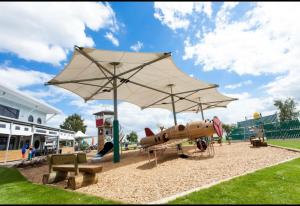 ein Spielplatz mit einem Spielzeugflugzeug unter einem Regenschirm in der Unterkunft Rachel Retreat Caravan Kingfisher Court Tattershall Lake in Tattershall