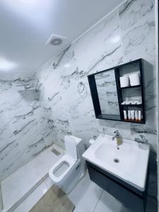 a white bathroom with a sink and a toilet at Rum STAR luxury camp in Wadi Rum