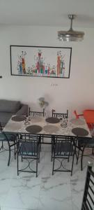 una mesa con sillas y una foto en la pared en Villa Shérazade, en Saint-Louis