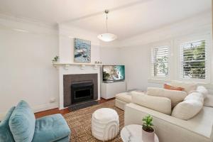 a living room with white furniture and a fireplace at Gorgeous 3 bed 5 mins walk Shelly, Fairy Bower, Manly Beaches in Sydney