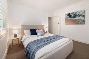 a bedroom with a large bed and a painting on the wall at Gorgeous 3 bed 5 mins walk Shelly, Fairy Bower, Manly Beaches in Sydney