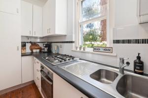 a kitchen with a sink and a stove and a window at Gorgeous 3 bed 5 mins walk Shelly, Fairy Bower, Manly Beaches in Sydney