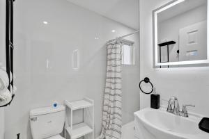 une salle de bain blanche avec toilettes et lavabo dans l'établissement Heart of Miami Oasis, Modern, Steps from It All, à Miami