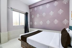 a bedroom with a bed and a window at HOTEL O TRINAY in Dhanbād