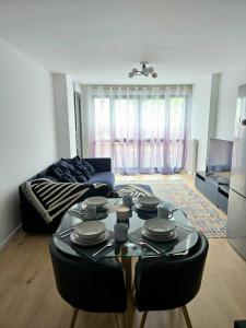un salon avec une table et un canapé dans l'établissement 1 min from Paris metro, Quiet, 2 bedrooms & private parking, à Aubervilliers