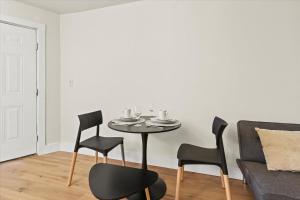 una mesa y sillas en una sala de estar con sofá en King Bed Modern Studio Apartment, en Huntsville