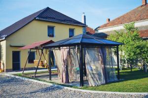 a playground with a swing and a canopy in front of a house at Casa Anca Hațeg in Haţeg