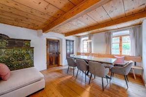 una sala da pranzo con tavolo e sedie di Stube & Stories - Heritage Riverside Home a Garmisch-Partenkirchen