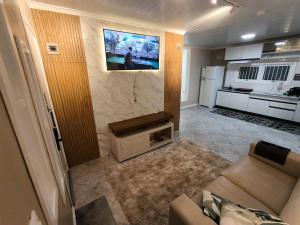 a living room with a couch and a tv on a wall at Pousada Serra Farroupilha in Farroupilha +80 photos