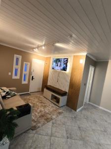 a living room with a flat screen tv on the wall at Pousada Serra Farroupilha in Farroupilha