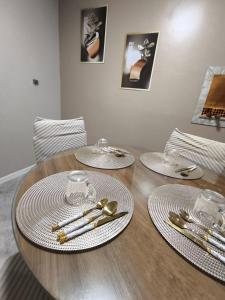 a wooden table with plates and utensils on it at Pousada Serra Farroupilha in Farroupilha