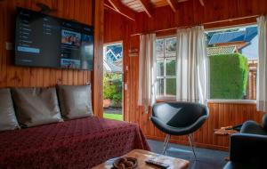 a bedroom with a bed and a tv and a chair at Sol y Nieve in San Martín de los Andes +17 photos