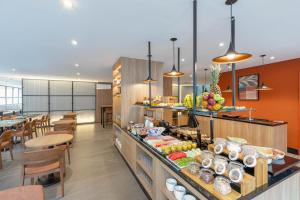 a restaurant with a buffet with fruits on it at Cozzy Premium Paulista Hotel in Sao Paulo