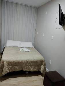 ein Schlafzimmer mit Bett und Flachbildfernseher in der Unterkunft Juarez Hotel in Campo Belo do Sul + 3 Fotos