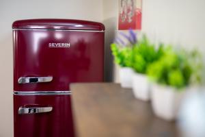 un réfrigérateur rouge avec un panneau dessus à côté des plantes dans l'établissement Casa Gianna Holiday Home, à Rutigliano