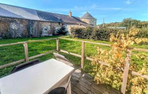 a table and chairs on a deck in front of a house at Gite Avec Piscine in Parennes