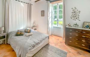 a bedroom with a bed and a dresser and a window at Gite Avec Piscine in Parennes