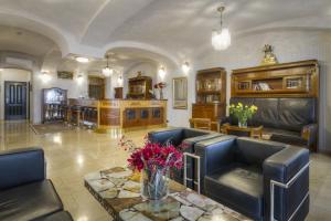 a living room with couches and a table with flowers at Hotel Mucha in Prague
