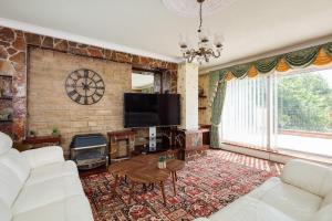 a living room with a couch and a tv at Beautiful 'Mayfield' Villa with private pool! in Manchester