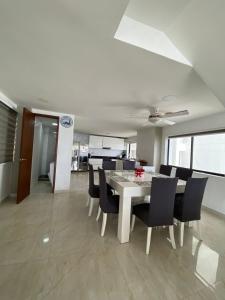 une salle à manger avec une table blanche et des chaises noires dans l'établissement APTO DUPLEX MARINA DEL REY CARTAGENA, à Carthagène des Indes 8 autres photos