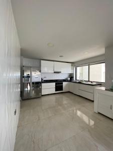 une grande cuisine avec des armoires et des appareils blancs dans l'établissement APTO DUPLEX MARINA DEL REY CARTAGENA, à Carthagène des Indes