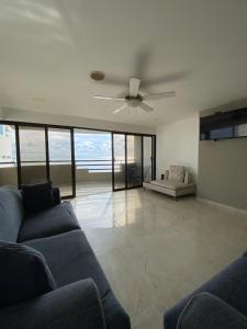 un salon avec un canapé et un ventilateur de plafond dans l'établissement APTO DUPLEX MARINA DEL REY CARTAGENA, à Carthagène des Indes