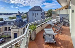a balcony with a table and chairs on a building at Gorgeous Apartment In Dinard With House Sea View in Dinard