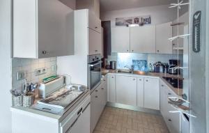 a kitchen with white cabinets and a sink at Gorgeous Apartment In Dinard With House Sea View in Dinard