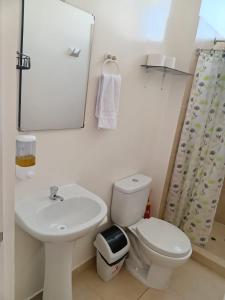 a bathroom with a toilet and a sink and a mirror at Sweet Home - Departamento en Tarapoto in Tarapoto