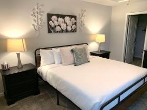 a bedroom with a bed with two lamps and flowers on the wall at 2059 Pinnacle Walk Drive Norcross in Norcross
