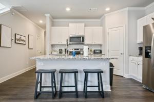 a kitchen with white cabinets and a counter with stools at 2059 Pinnacle Walk Drive Norcross in Norcross +20 photos