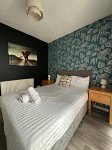 a bedroom with a large bed with blue and white sheets at Luxurious Room in Hackington