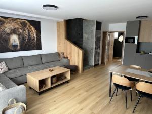 Una sala de estar con un cuadro de un oso pardo en la pared. en Apartmán s výhľadom, en Stará Lesná