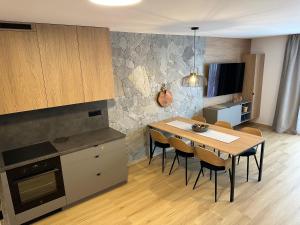 Una cocina con una mesa y sillas en una habitación. en Apartmán s výhľadom, en Stará Lesná 10 fotos más