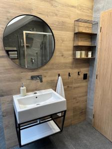 Un baño con un lavabo blanco y un espejo. en Apartmán s výhľadom, en Stará Lesná