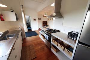 a kitchen with a sink and a stove top oven at The Cottage on the Olive Grove in Russell