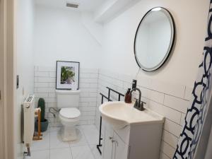 a white bathroom with a sink and a mirror at 10 Minute walk to Light Rail in Jersey City +11 photos