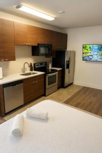 Una cocina con electrodomésticos de acero inoxidable y gabinetes de madera. en Venice Beach 2BR - 7-Min Walk - Pool, Hot Tub & Gym, en Los Ángeles