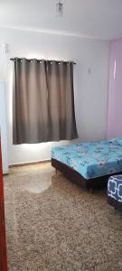 - une chambre avec un lit et un rideau dans l'établissement Kitnet montanha mágica, à São Thomé das Letras